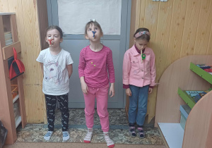 Zajęcia logopedyczne - uczennice wykonują ćwiczenia oddechowe z wykorzystaniem dmuchajek