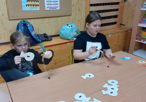 Zabawa w wędkarza.Za pomocą wędki uczestnicy łapią rybki z obrazkami, których nazwy zawierają głoski szumiące, ćwiczenia słuchowe.