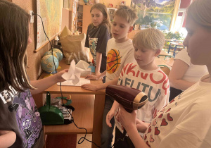 Uczniowie w ramach koła ekologiczno-przyrodniczego wykonują doświadczenia - Jak ustawić wiatrak względem wiatru, aby uzyskać jak najwięcej energii.