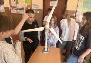 Uczniowie koła ekologiczno-przyrodniczego na podstawie modelu poznają budowę i działanie wiatraka służącego do wytwarzania energii.