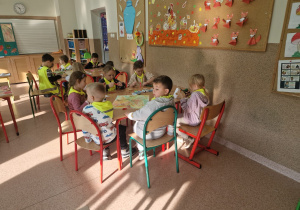Przedszkolaki wykonują prace plastyczne oparte na jesiennych inspiracjach.