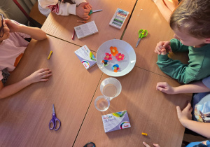 Przedszkolaki wykonują eksperyment „Rozkwitające kwiaty”