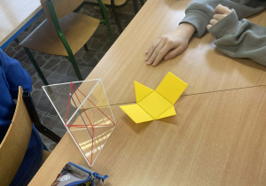 Uczniowie pracują z modelami brył aby lepiej zrozumieć pojęcia geometryczne