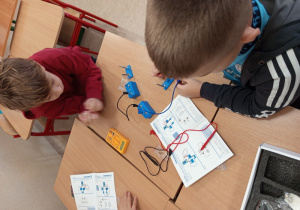 Grupa uczniów buduje proste obwody elektryczne.