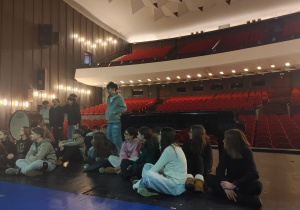 Uczestnicy szkolnej wycieczki przebywają na scenie głównej Teatru Wielkiego.