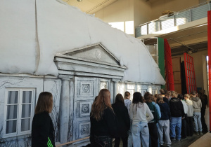 Uczniowie oglądają elementy scenografii teatralnej.