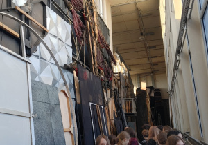 Klasa 7b zwiedza zakątki Teatru Wielkiego podziwiając dekoracje.