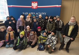 Wspólne zdjęcie uczniów klasy 2a na tle napisu Sąd Apelacyjny.