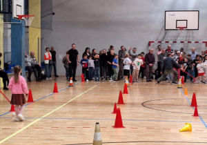 Uczestnicy konkurencji sportowych, w wybranych drużynach czekają na sali gimnastycznej na rozpoczęcie pierwszej konkurencji.