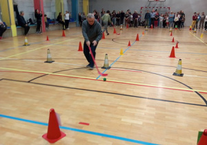 Każda z drużyn pokonuje slalom między pachołkami , prowadząc piłkę kijem do unihokeja.