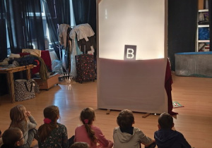 Dzieci oglądają teatr cieni.