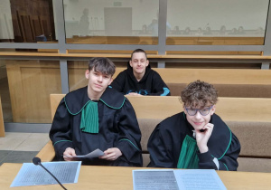 Uczniowie siedzą w ławach sądowych podczas odgrywanej symulacji sprawy według ustalonego scenariusza.