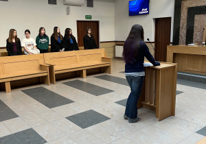 Uczniowie podczas symulacji sprawy sądowej w roli obrońców, prokuratorów i obrońców.