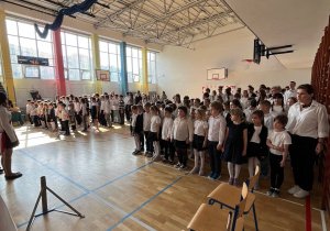 Uczniowie i nauczyciele uczestniczący w uroczystym apelu.