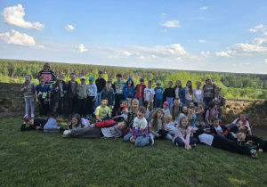 Uczniowie klasy 1b i 2a stoją na tle murów wokół kościoła w Inowłodzu.