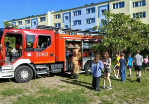 Policjanci, motocykl i samochód policyjny podczas pikniku w Szkole Podstawowej nr 137