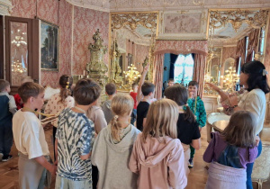 Dzieci zwiedzają muzeum, oglądają eksponaty muzealne