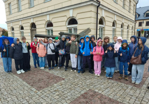 Uczniowie z klasy 4b stoją na Rynku w Łęczycy.